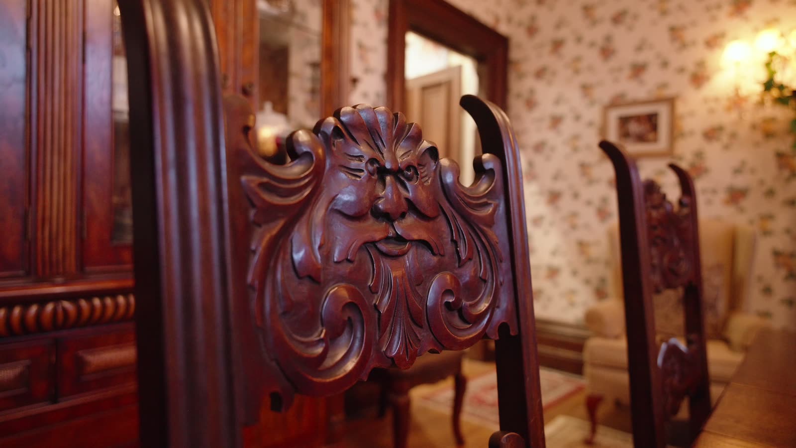 A carved wooden face on a dining chair at Inverlorne