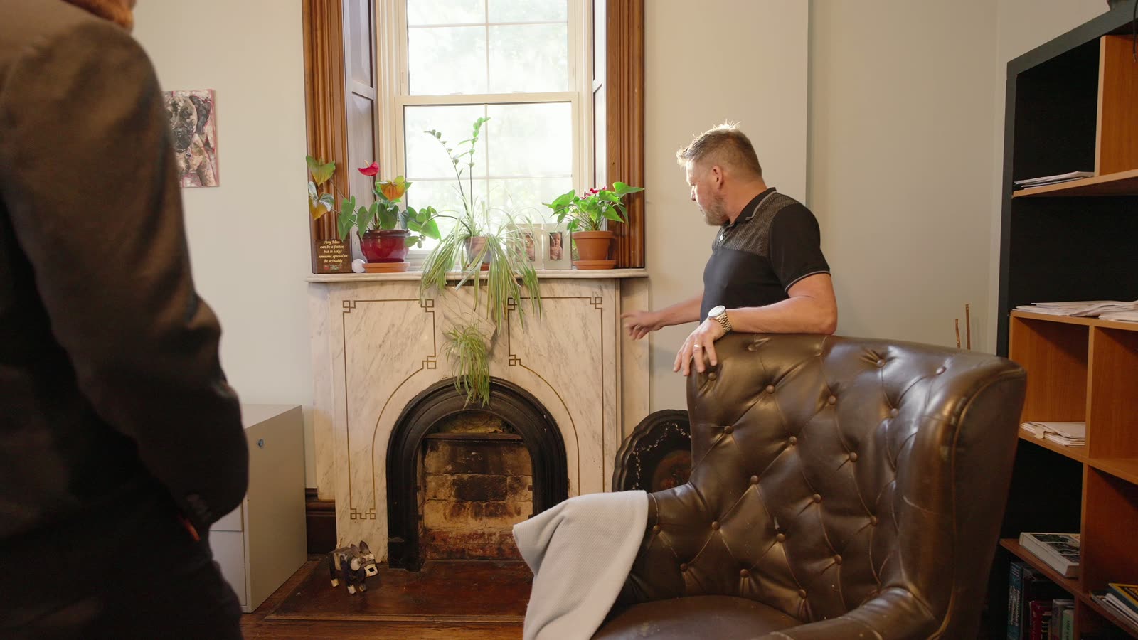 A marble fireplace with a window directly above it